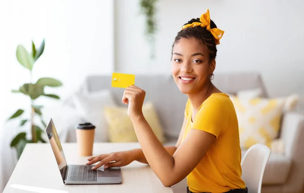 Mujer negra usando laptop y tarjeta de crédito en casa — Foto de Stock