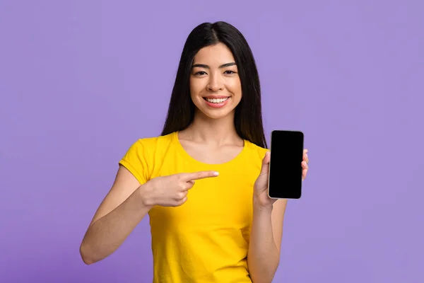 Vê isto. alegre ásia senhora apontando para Smartphone com preto branco tela — Fotografia de Stock