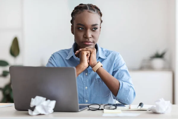 Inspiratieprobleem. Bedachtzame zwarte freelancer vrouw zitten op de werkplek in het thuiskantoor — Stockfoto