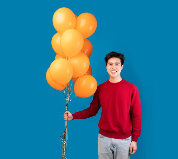 Casual asiático chico sosteniendo un montón de amarillo globos —  Fotos de Stock