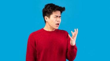 Asyalı adam yanlış öksürüyor ve hapşırıyor.