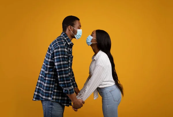 戴着防护面具恋爱的非洲裔美国夫妇想亲吻对方，保持距离 — 图库照片