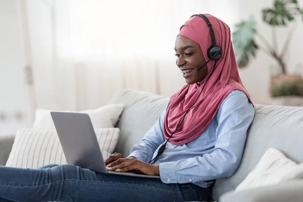 Aprendizagem online. Africano mulher islâmica no fone de ouvido Stydying em casa com laptop — Fotografia de Stock