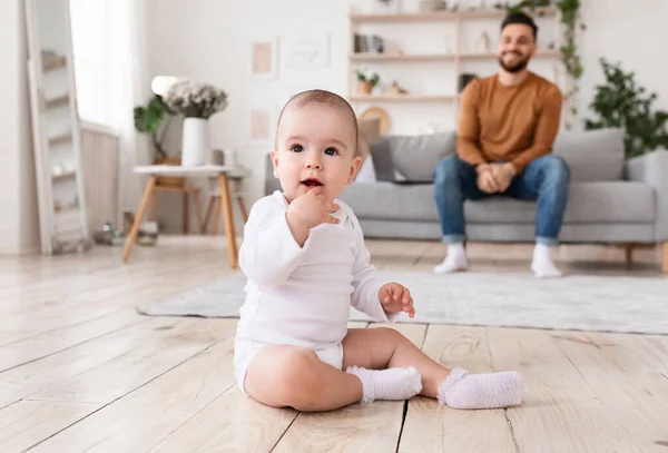 Şirin küçük bebek ve oturma odasında oturan baba. — Stok fotoğraf