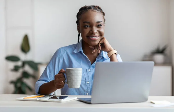 Pensivo jovem preto feminino freelancer beber café no local de trabalho em casa escritório — Fotografia de Stock