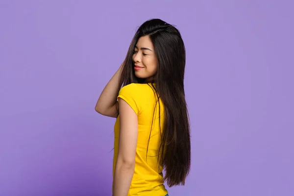 Joven mujer asiática con hermoso pelo largo natural posando sobre fondo púrpura — Foto de Stock
