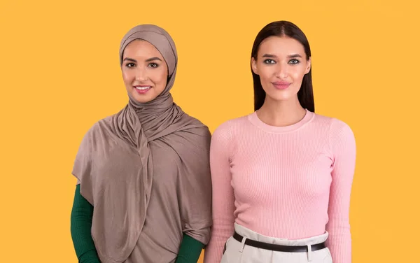 Wanita Muslim dan Wanita Kaukasia Posing Over Yellow Background — Stok Foto