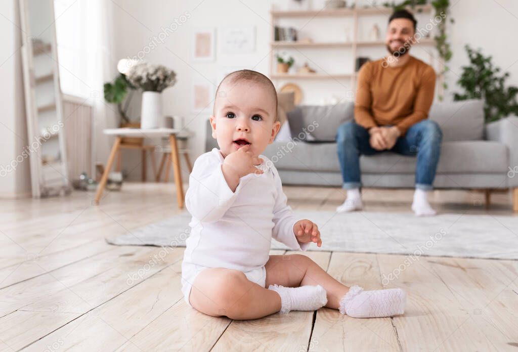 Cute Little Baby And Father Sitting In Living Room Indoor