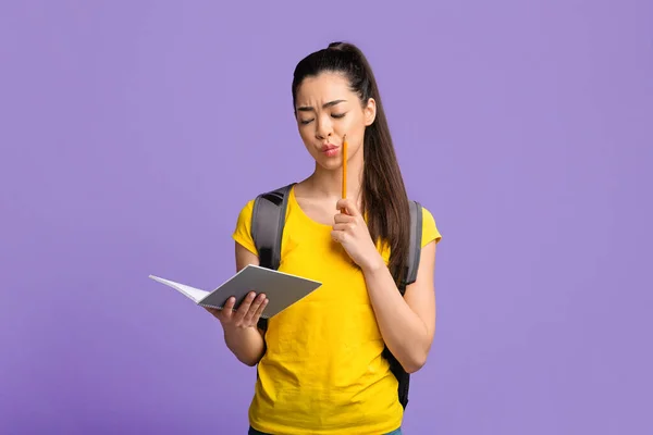 Lernkonzept. Asiatische Studentin liest etwas in Notizblock und bereitet sich auf Prüfungen vor — Stockfoto