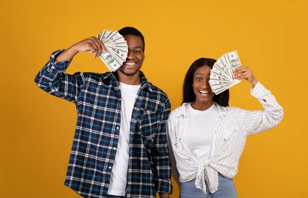 Jovem senhora afro-americana feliz e cara fechar os olhos com dólares e se alegrar com a vitória no auto-isolamento — Fotografia de Stock