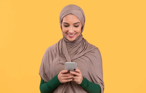 Cep Telefonu Mesajı Kullanan Neşeli Arap Kadın Stüdyoda Duruyor — Stok fotoğraf