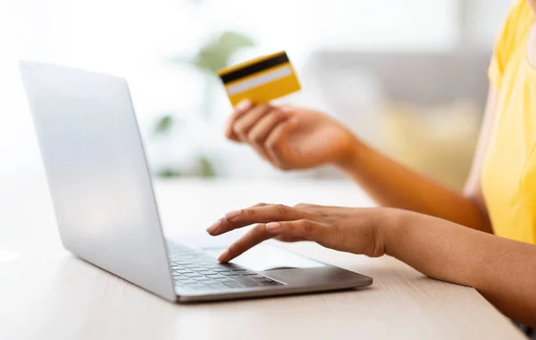 Svart kvinna som använder laptop och kreditkort sitter vid skrivbordet — Stockfoto
