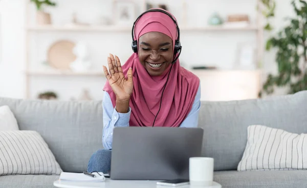Telekonferans. Gülümseyen siyah Müslüman kadın bilgisayarla video görüşmesi yapıyor. — Stok fotoğraf