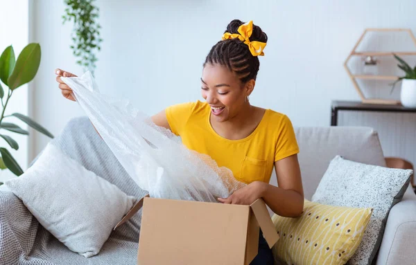 Ευτυχισμένο μαύρο κυρία ξεπακετάρισμα κουτί μετά από online ψώνια — Φωτογραφία Αρχείου