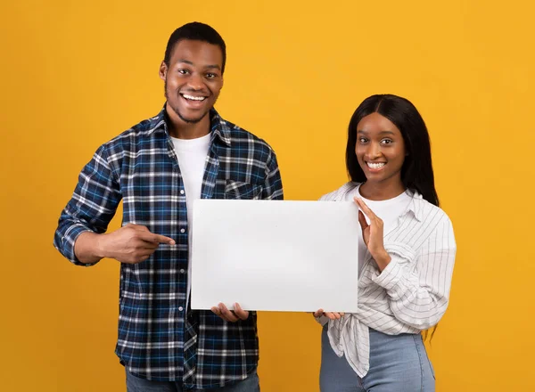 Cheerful young african american male and female holding banner with blank space — Stock Photo, Image