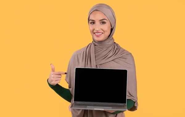 Muslim Lady Menunjuk Pada Layar Kosong Laptop, Latar Belakang Kuning, Mockup — Stok Foto