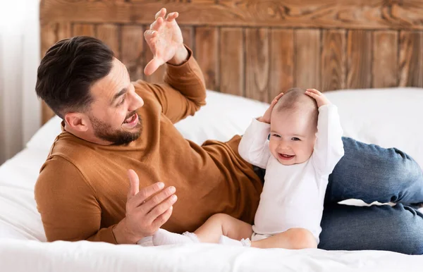 Jovem pai brincando com pouco bebê filha ligação em casa — Fotografia de Stock