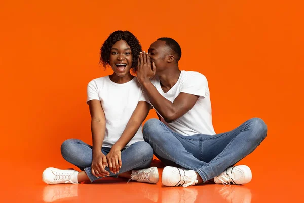 Zwart guy fluisteren geheimen naar zijn vriendin — Stockfoto