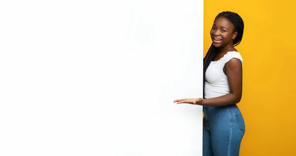 Черная женщина указывает ладонью на место для копирования на белой рекламной доске — стоковое фото