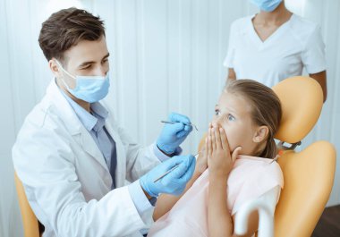 Çocuk dişçisi ve modern klinikte bebeklerle çalışıyor.