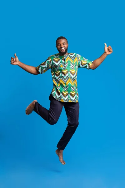 Pozitif siyah adam mavinin üzerinde zıplıyor — Stok fotoğraf
