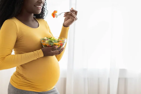 Irreconocible embarazada negro dama comer fresco ensalada, recortado — Foto de Stock