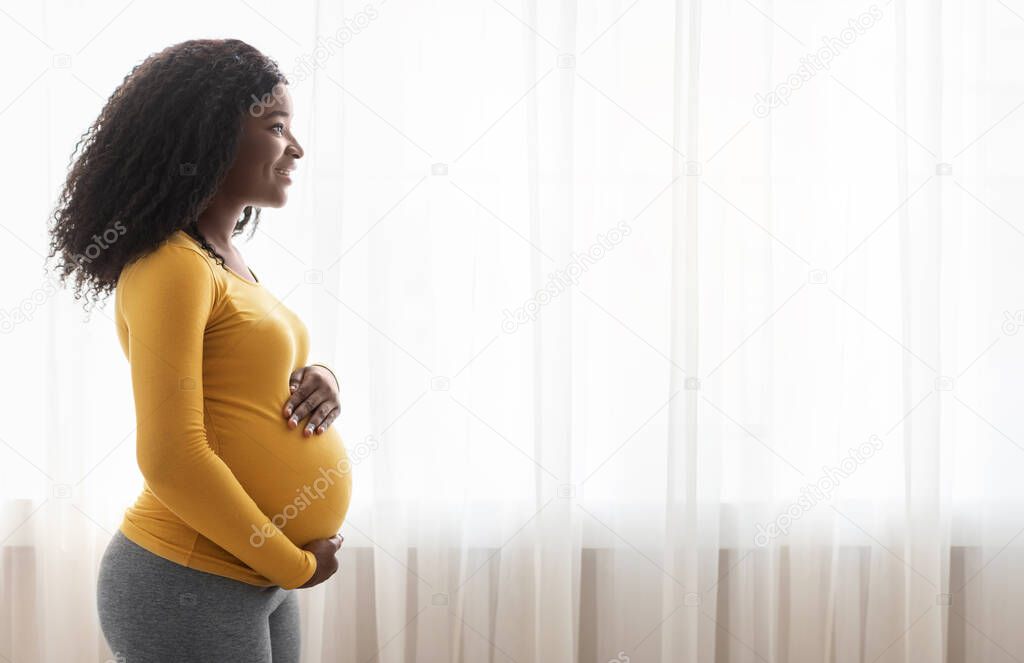 Black expecting lady looking at copy space