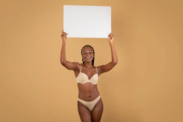 Vidám fekete vékony nő fehérneműben Pózol fehér üres Placard — Stock Fotó