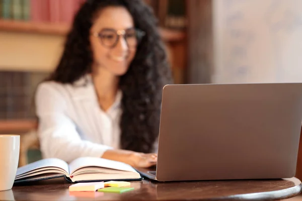 Mulher sentada na mesa, usando laptop, foco no notebook — Fotografia de Stock