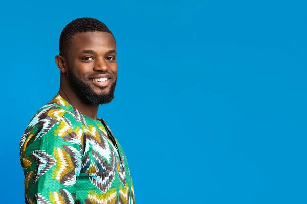 Positive black man in african shirt looking at camera — Stock Photo, Image