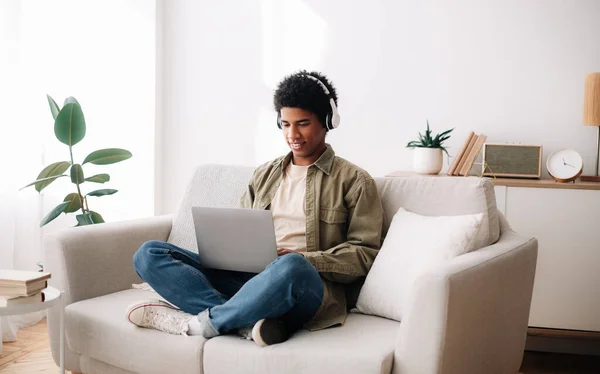 E-learning. Afro-americano adolescente estudante em fones de ouvido participando de conferência na web ou aula on-line sobre laptop — Fotografia de Stock