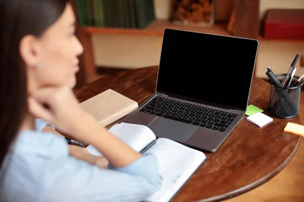 Femeia care stă la birou folosind laptop cu ecran gol, mockup — Fotografie, imagine de stoc