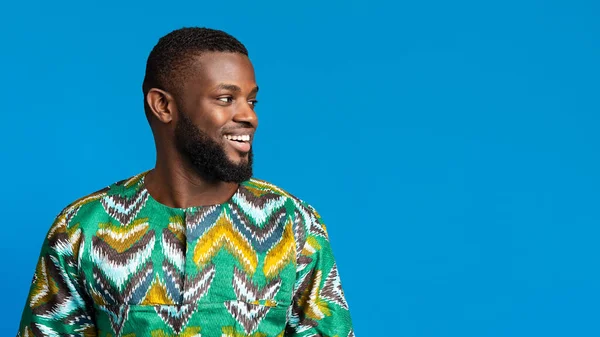 Positiv svart man i afrikansk skjorta tittar på kopieringsutrymme — Stockfoto