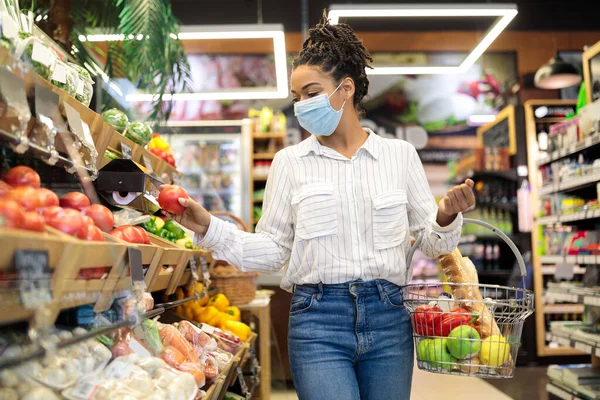 スーパーで新鮮な野菜を選ぶ黒人女性、バスケットと歩く — ストック写真