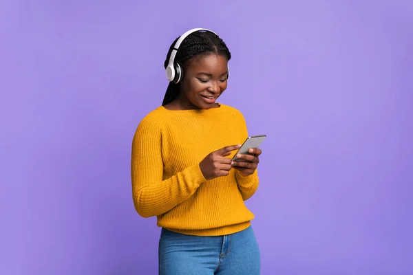 Modern technológiák a kikapcsolódásra. Black Woman Lsitening Zene Okostelefon és fejhallgató — Stock Fotó