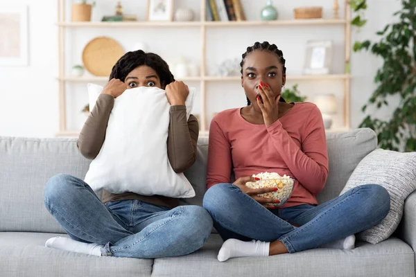 Skrämda svarta flickvänner tittar på skräck tillsammans hemma — Stockfoto