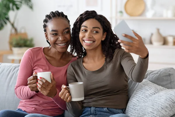 Gelukkig zwart besties het nemen van selfie op smartphone samen thuis — Stockfoto