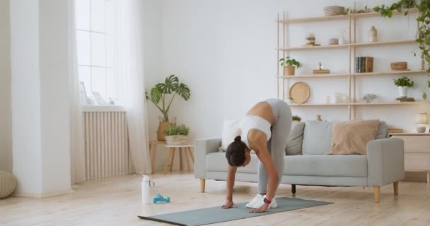 Exercício de alongamento doméstico. Jovem senhora afro-americana flexível inclinando-se em casa, chegando aos pés — Vídeo de Stock