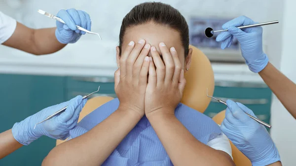 Médicos multirraciais em luvas de borracha assustar menina com instrumentos médicos — Fotografia de Stock