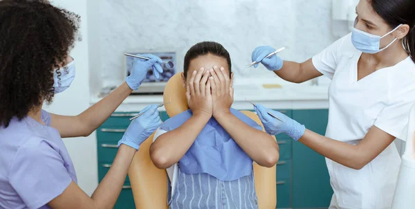 Little cute girl zamykając twarz z rąk, zapobiegając badaniu zębów, strach przed lekarzem — Zdjęcie stockowe