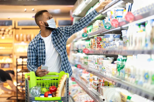 African Man Doing Grocery Shopping In Supermarket, Wearing Face Mask