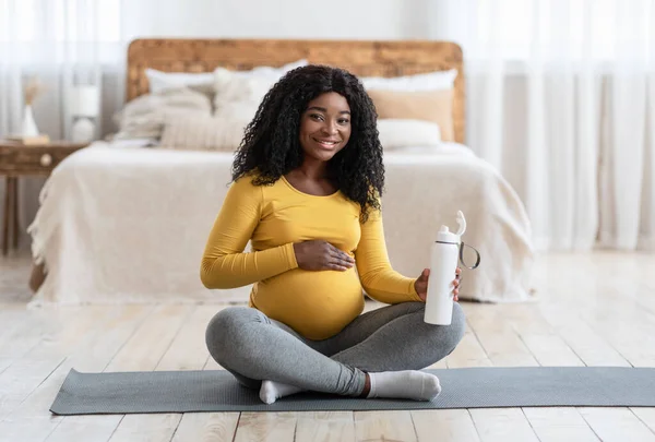 Grávida afro-americana senhora beber água durante o exercício — Fotografia de Stock