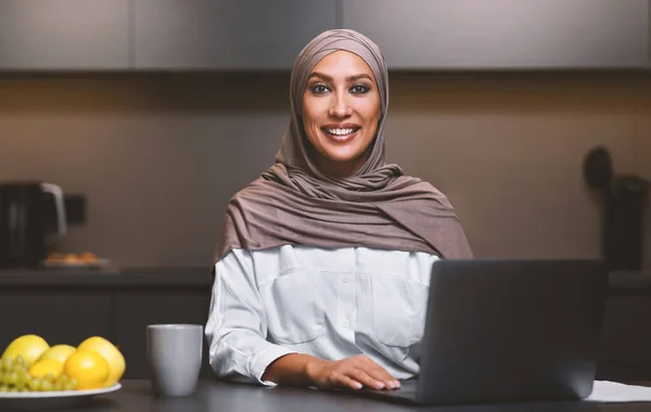 Allegra donna araba al computer portatile che lavora online a casa — Foto Stock