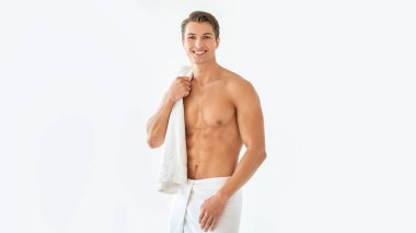 Stüdyoda havluya sarılmış gömleksiz yakışıklı adam.