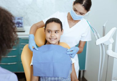 Genç bayan Afro-Amerikan doktor hemşireye bakıyor.