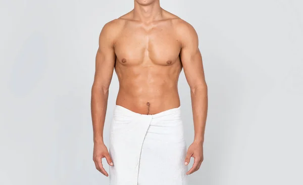 Unrecognizable shirtless young man standing wrapped in towel at studio — Stock Photo, Image