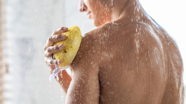 Jovem lavando seu corpo com esponja — Fotografia de Stock