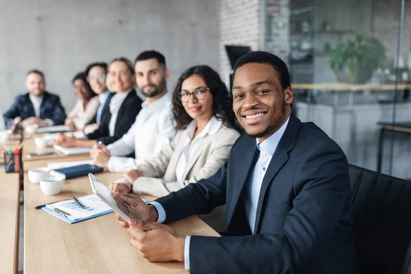 Empresario africano en reunión corporativa con colegas sentados en el cargo — Foto de Stock