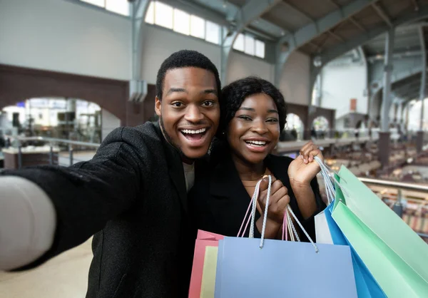 Datas amorosas com sacos de compras no shopping moderno da cidade — Fotografia de Stock