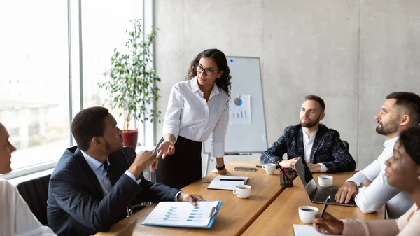 Empresaria en reunión de negocios hablando con colegas de pie en el cargo —  Fotos de Stock